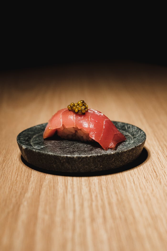 Stylish Japanese nigiri topped with golden caviar, showcasing fine culinary art.